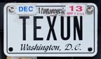 undated black-on-white personalized motorcycle plate TEXUN