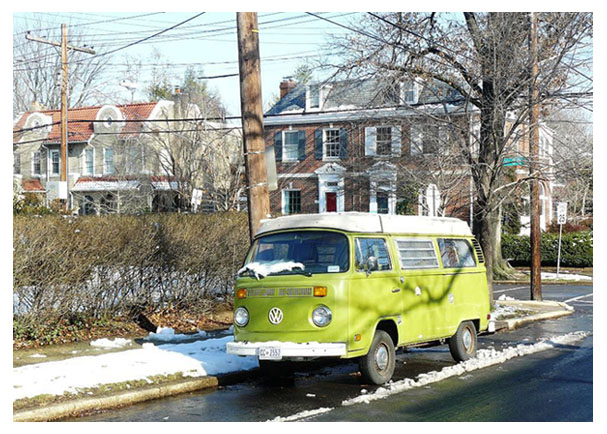 A Volkswagen camper parked on a residential D.C. street after a light snowfall.