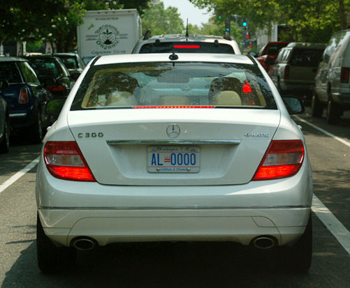D.C. auto plate no. AL-0000 on a Mercedes-Benz C300 stopped in traffic on a city street.